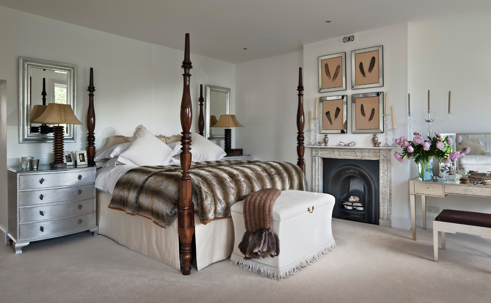 На фото: спальня в классическом стиле с белыми стенами, ковровым покрытием и стандартным камином с