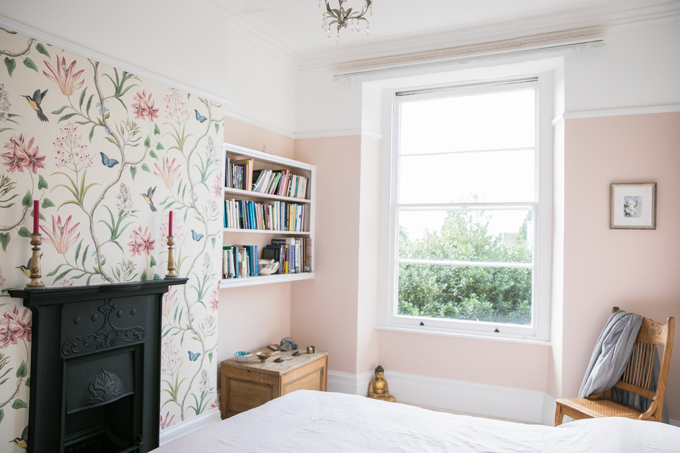 Идея дизайна: гостевая спальня (комната для гостей) в классическом стиле с розовыми стенами, стандартным камином и фасадом камина из металла