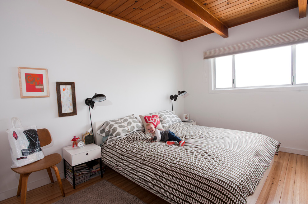 Inspiration för ett minimalistiskt sovrum, med vita väggar och ljust trägolv