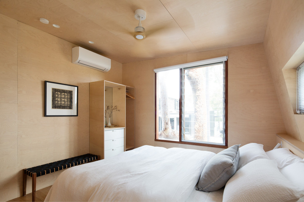 Ejemplo de dormitorio tipo loft contemporáneo con suelo de madera en tonos medios, machihembrado y madera
