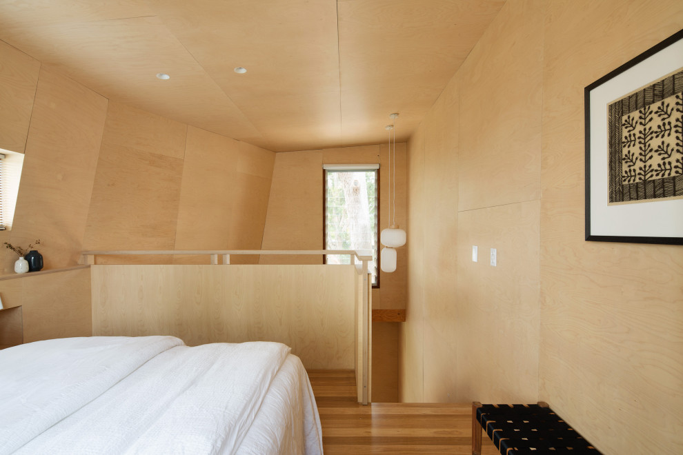 Cette photo montre une chambre mansardée ou avec mezzanine tendance en bois avec un sol en bois brun et un plafond en lambris de bois.
