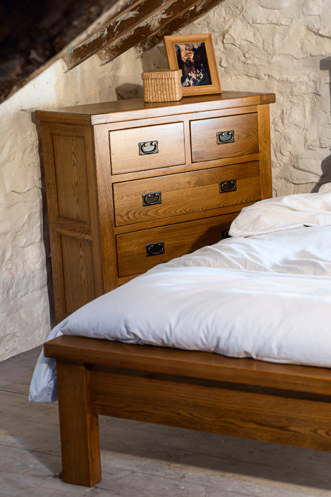 Modelo de dormitorio tipo loft rural de tamaño medio sin chimenea con paredes blancas y suelo de madera clara