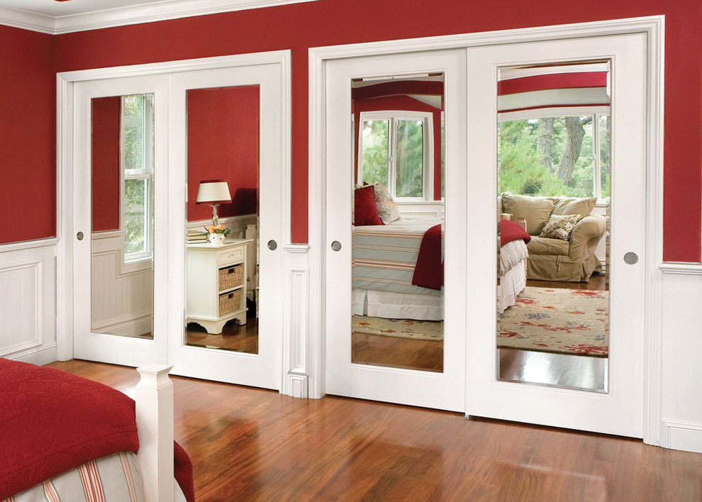 Cette photo montre une chambre parentale tendance de taille moyenne avec un mur rouge et parquet foncé.