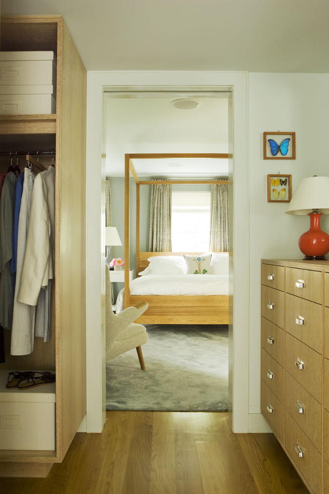 Esempio di una camera da letto contemporanea con pareti bianche e pavimento in legno massello medio