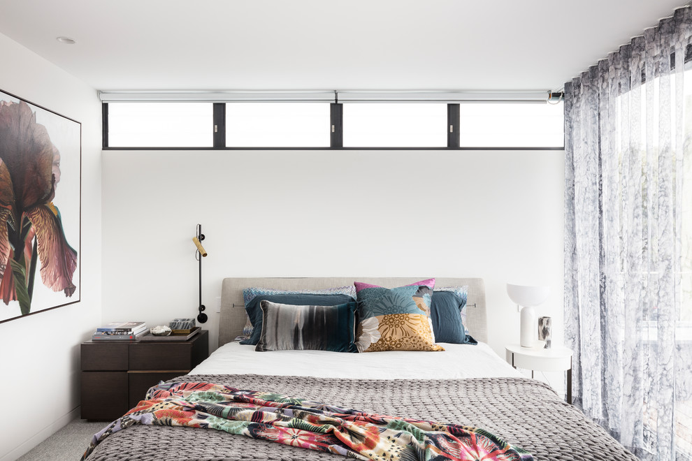 Immagine di una camera degli ospiti contemporanea con pareti bianche, moquette e pavimento grigio