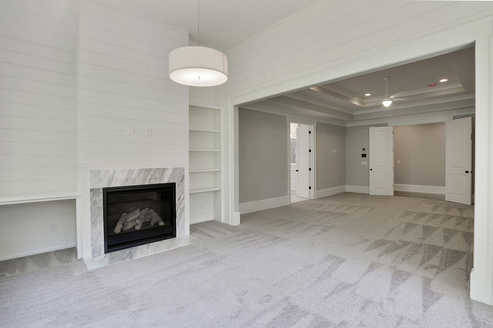 Idée de décoration pour une grande chambre design avec un mur gris, une cheminée standard et un manteau de cheminée en pierre.