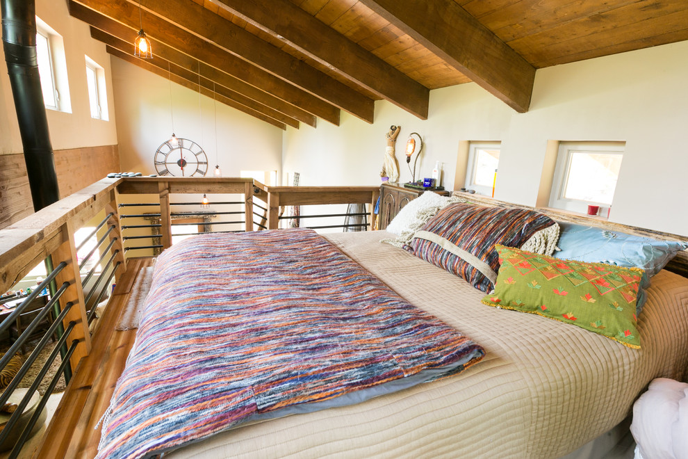 Kleines Rustikales Schlafzimmer im Loft-Style mit beiger Wandfarbe und braunem Holzboden in Denver