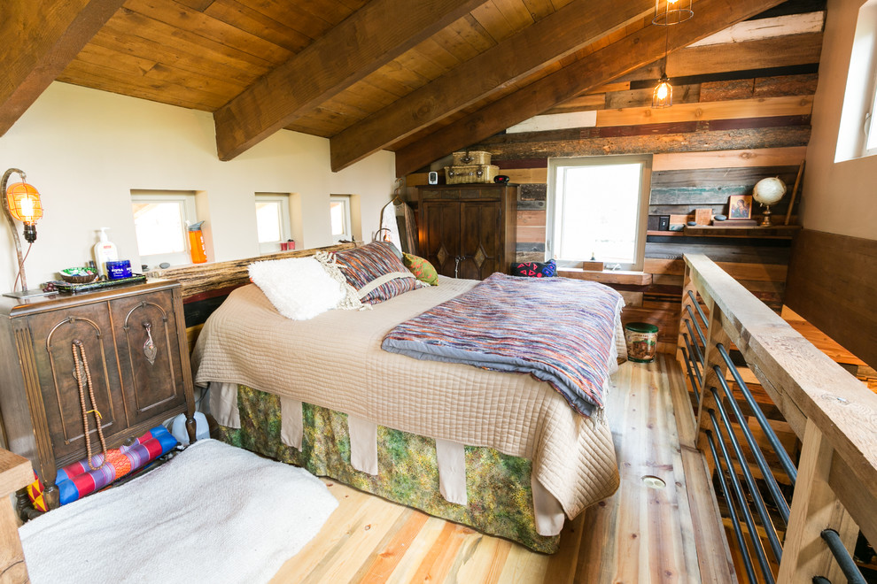Small rustic mezzanine bedroom in Denver with beige walls and medium hardwood flooring.