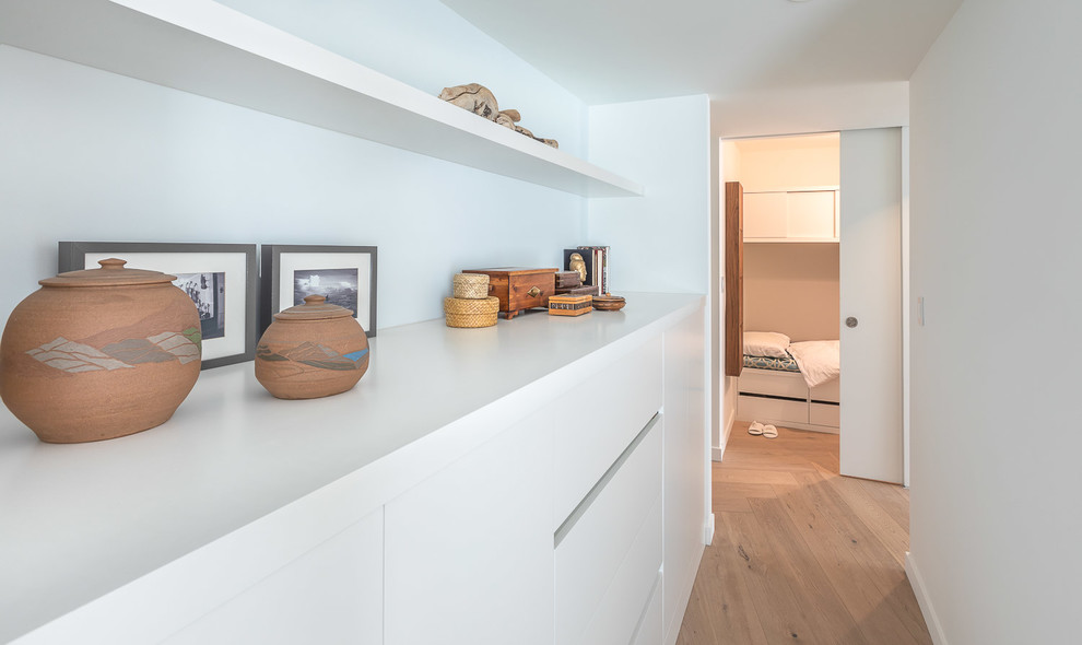 Foto di una piccola camera da letto stile loft design con pareti bianche e parquet chiaro