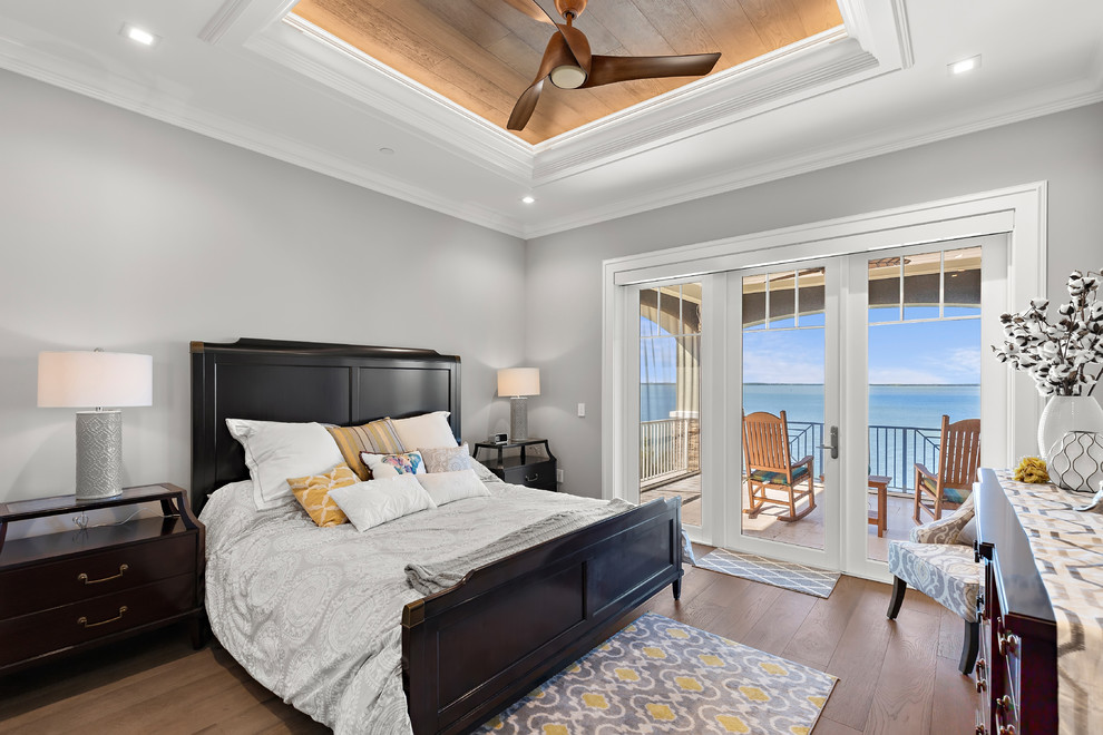 Maritimes Schlafzimmer mit grauer Wandfarbe, dunklem Holzboden und braunem Boden in Tampa