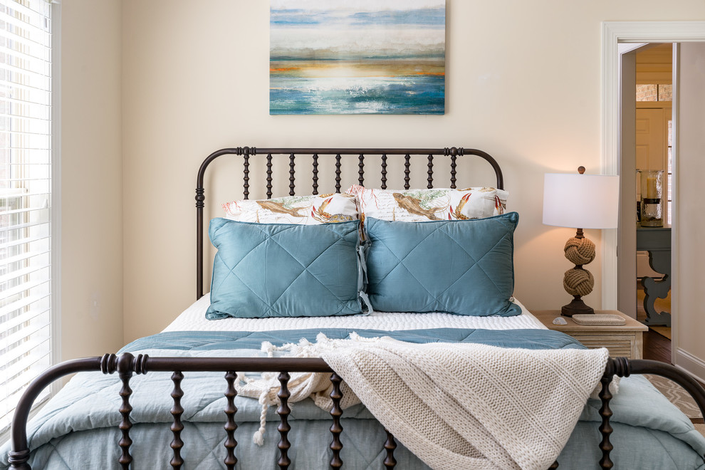 This is an example of a small coastal guest bedroom in Wilmington with beige walls and carpet.