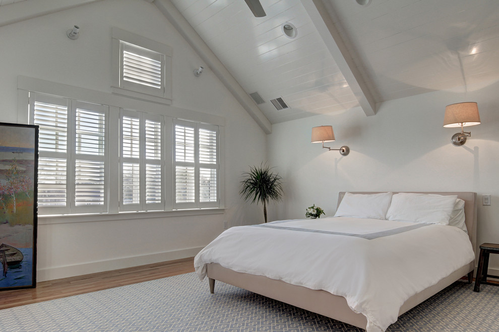 Modelo de dormitorio tradicional renovado con paredes blancas y suelo de madera en tonos medios