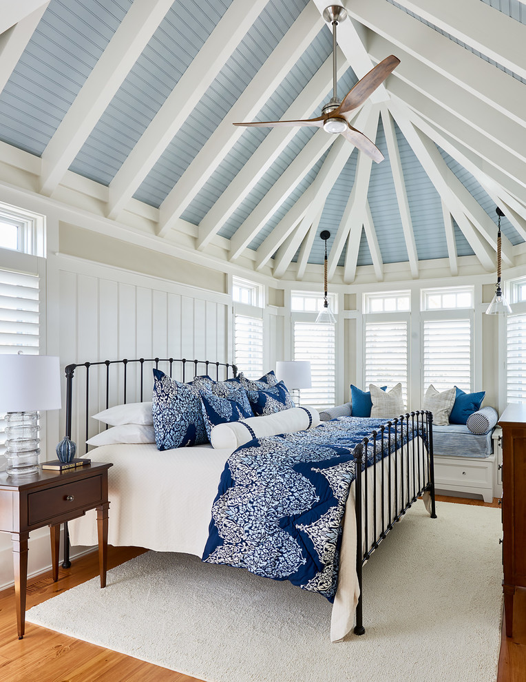 Ejemplo de dormitorio principal marinero sin chimenea con paredes beige y suelo de madera en tonos medios
