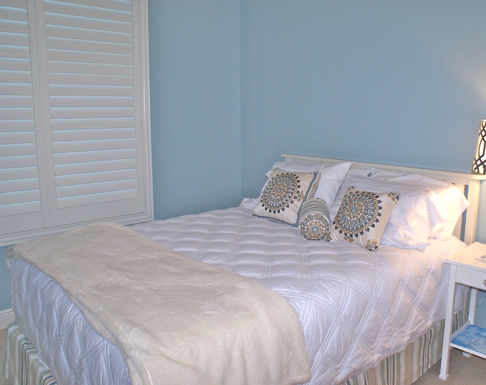 Maritimes Gästezimmer mit blauer Wandfarbe und Teppichboden in Tampa