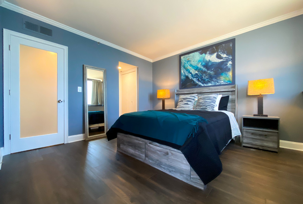 Aménagement d'une chambre parentale bord de mer de taille moyenne avec un mur bleu, un sol en vinyl et un sol marron.