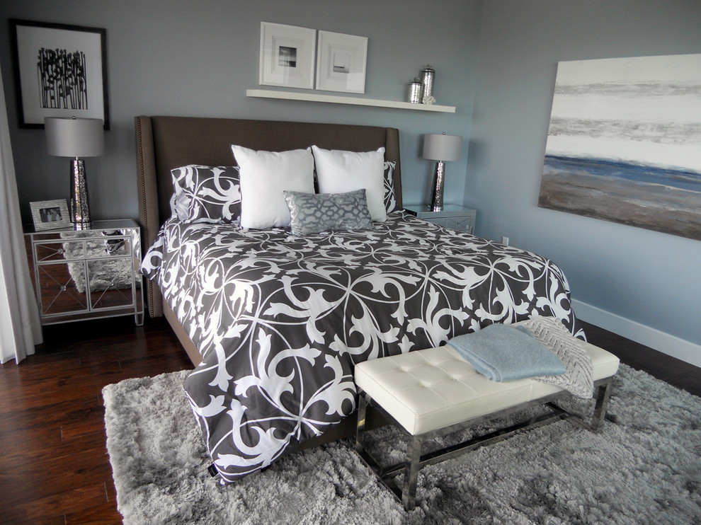 Modelo de dormitorio principal contemporáneo de tamaño medio sin chimenea con paredes azules y suelo de madera en tonos medios