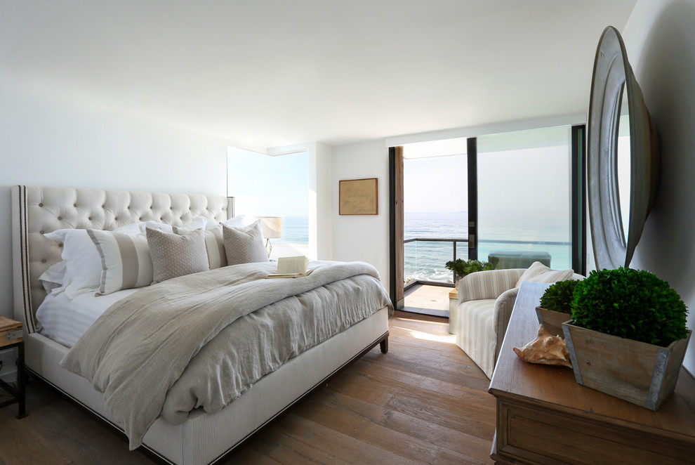 На фото: хозяйская спальня среднего размера в морском стиле с белыми стенами, темным паркетным полом и коричневым полом без камина с