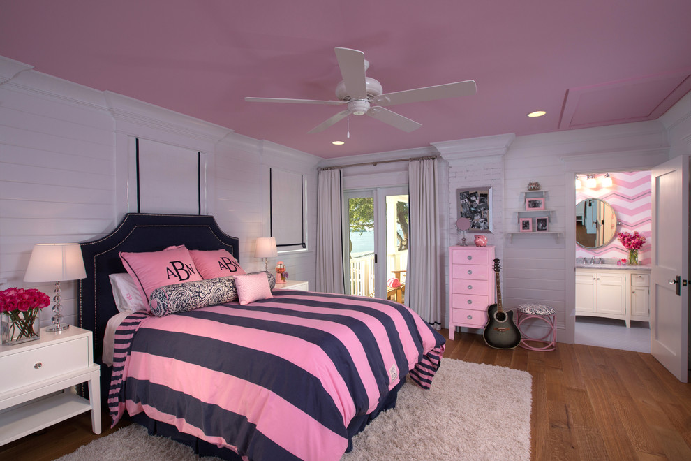 Modelo de dormitorio contemporáneo grande sin chimenea con paredes rosas y suelo de madera en tonos medios
