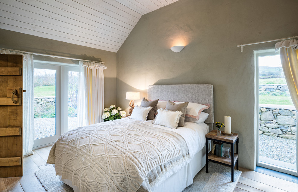 Imagen de dormitorio marinero sin chimenea con paredes grises y suelo de madera clara