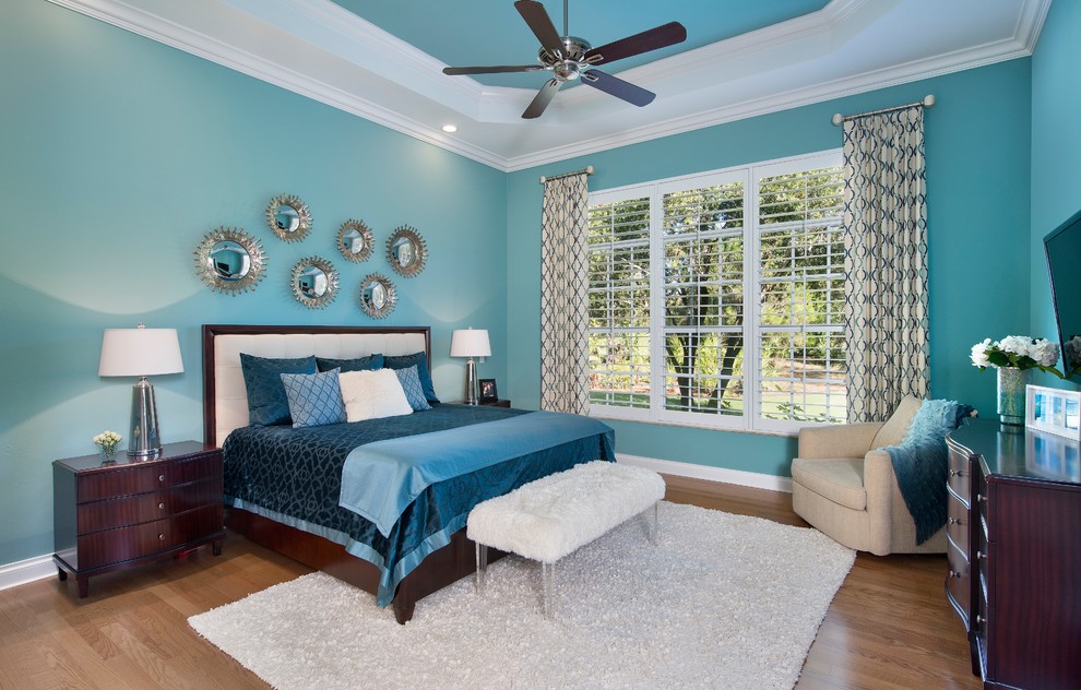 Ejemplo de dormitorio principal tradicional renovado grande con paredes azules y suelo de madera en tonos medios