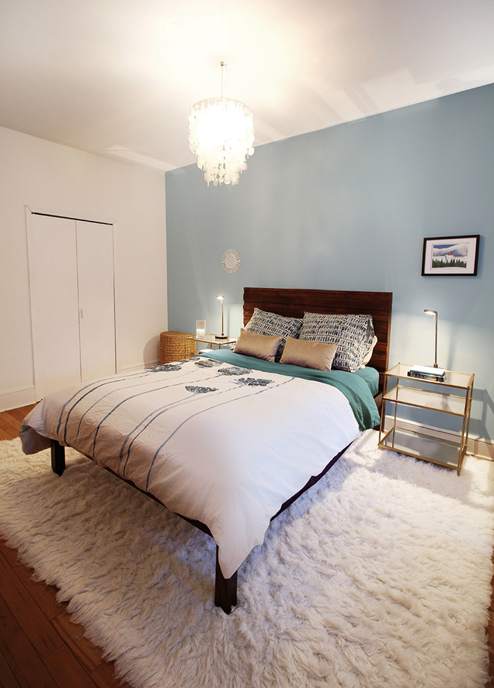 Idée de décoration pour une chambre parentale design de taille moyenne avec un mur multicolore et un sol en bois brun.