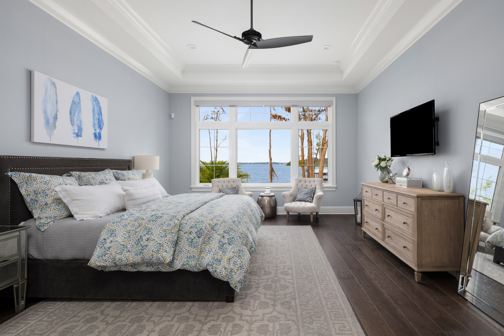 Пример оригинального дизайна: большая хозяйская спальня в морском стиле с синими стенами, темным паркетным полом и коричневым полом без камина