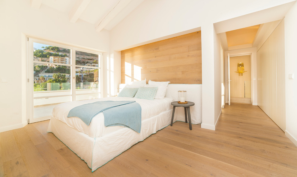 Foto de dormitorio principal marinero de tamaño medio sin chimenea con paredes blancas y suelo de madera en tonos medios