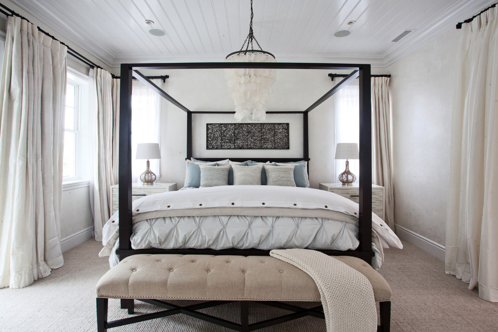 Inspiration for a large coastal master bedroom in Orange County with beige walls, carpet, no fireplace and feature lighting.