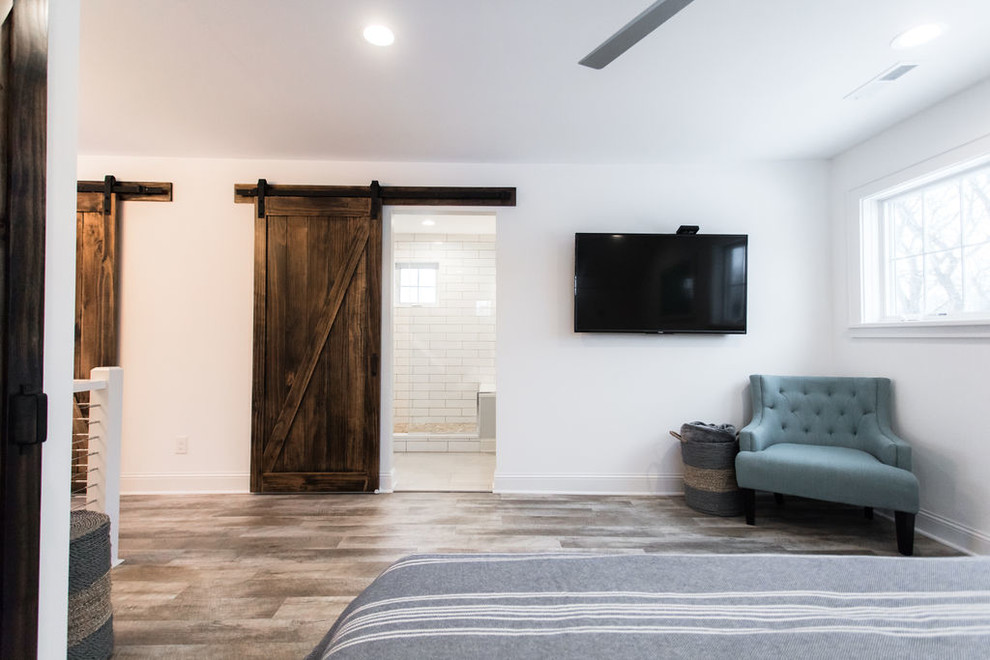 Mittelgroßes Country Hauptschlafzimmer ohne Kamin mit weißer Wandfarbe, braunem Holzboden und braunem Boden in Minneapolis