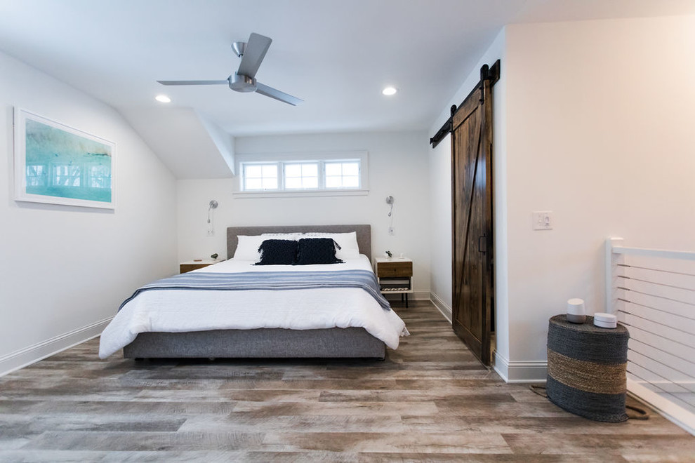 Foto de dormitorio principal costero de tamaño medio sin chimenea con paredes blancas, suelo de madera en tonos medios y suelo marrón