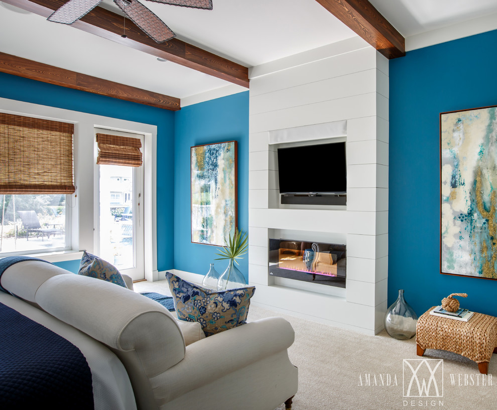 Exemple d'une chambre bord de mer avec un mur bleu, une cheminée standard et un manteau de cheminée en bois.