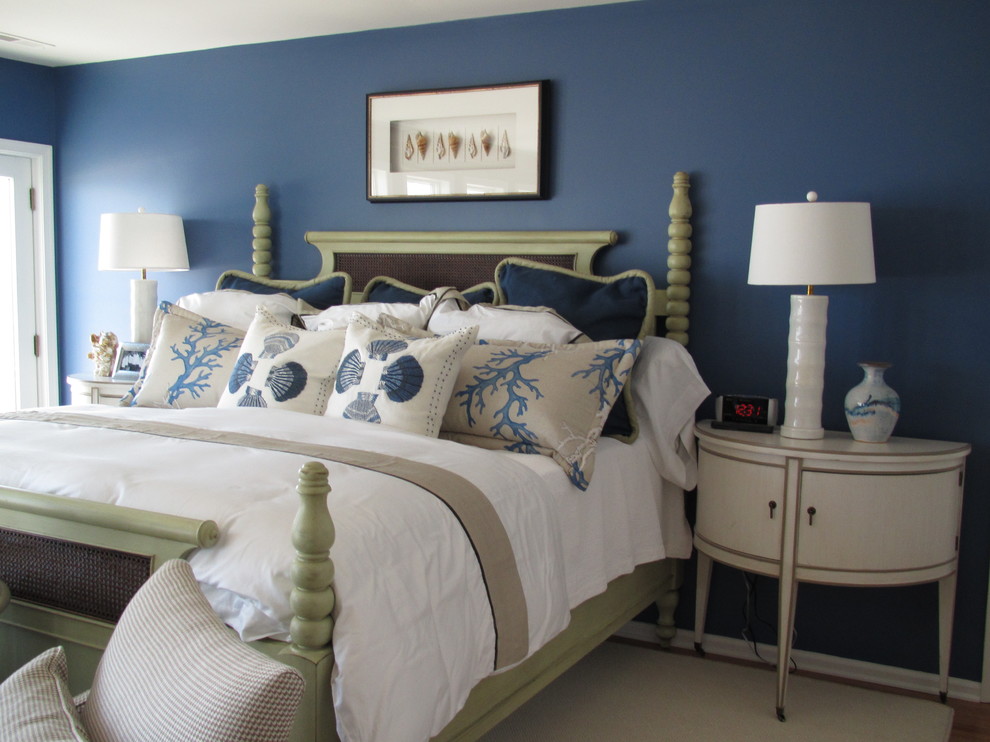 Aménagement d'une chambre parentale bord de mer de taille moyenne avec un mur bleu, parquet foncé, aucune cheminée et un sol marron.