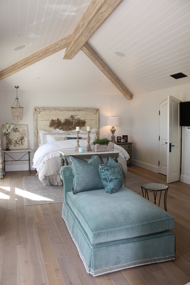 Imagen de dormitorio principal costero grande con paredes blancas y suelo de madera clara