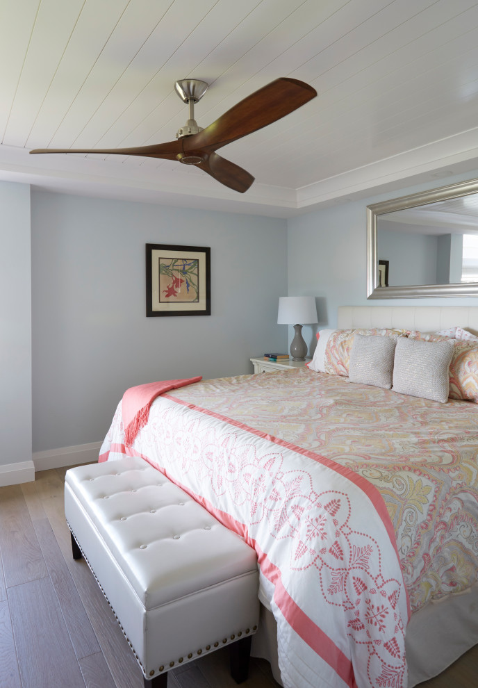 Ejemplo de habitación de invitados costera de tamaño medio con paredes azules, suelo de madera en tonos medios, suelo marrón y machihembrado