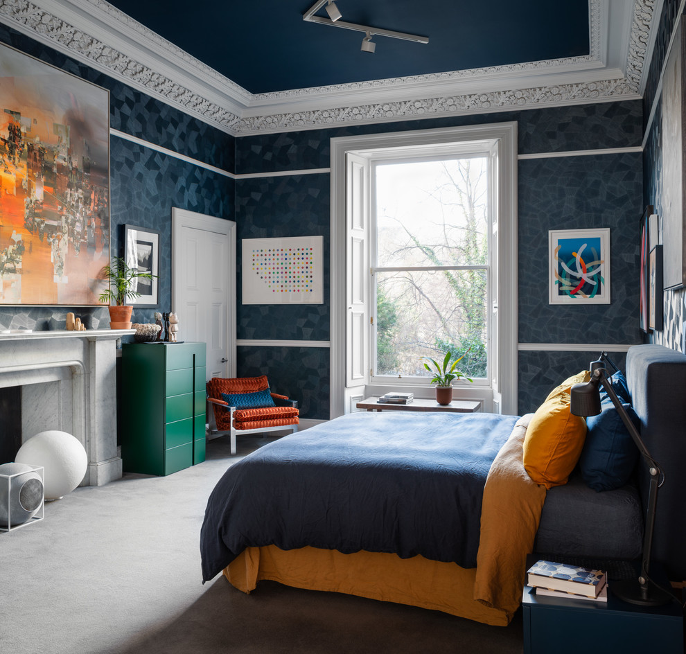 На фото: большая хозяйская спальня в современном стиле с синими стенами, ковровым покрытием, стандартным камином, фасадом камина из камня и серым полом