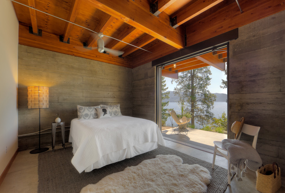 Diseño de dormitorio minimalista sin chimenea con paredes blancas y suelo de cemento
