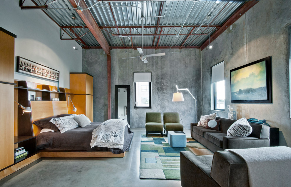 Foto di una camera matrimoniale industriale con pareti grigie e pavimento in cemento