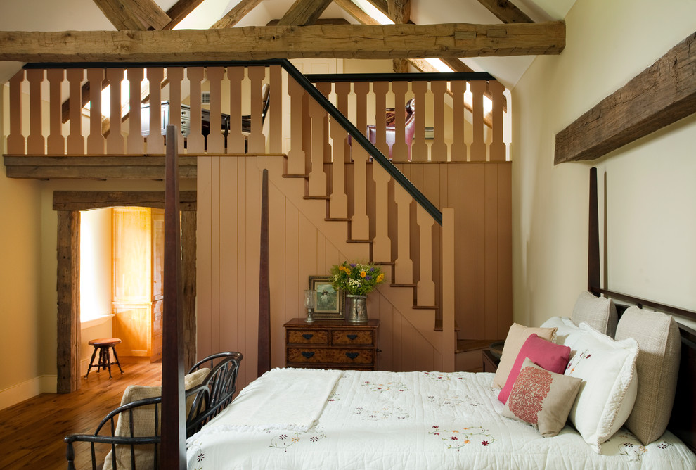 Inspiration pour une chambre parentale rustique avec un mur beige, un sol en bois brun, aucune cheminée et un sol marron.
