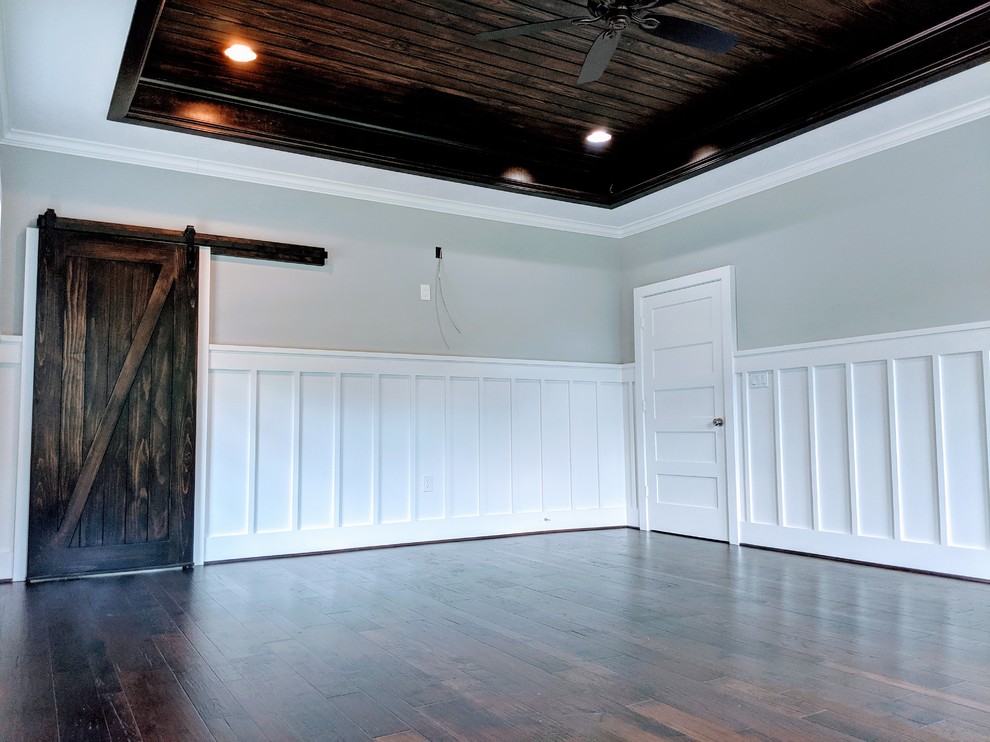 Пример оригинального дизайна: большая хозяйская спальня в белых тонах с отделкой деревом в стиле модернизм с серыми стенами, темным паркетным полом, коричневым полом, многоуровневым потолком и панелями на стенах без камина