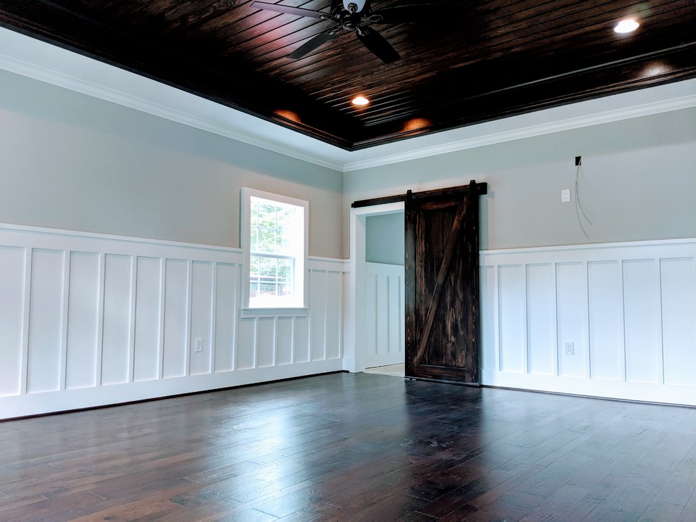 Foto på ett stort funkis huvudsovrum, med grå väggar, mörkt trägolv och brunt golv