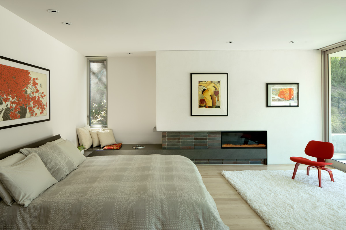 Bedroom - modern bedroom idea in Los Angeles with a ribbon fireplace