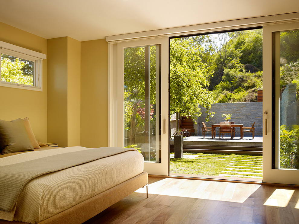 This is an example of a modern bedroom in San Francisco with beige walls, medium hardwood flooring and beige floors.