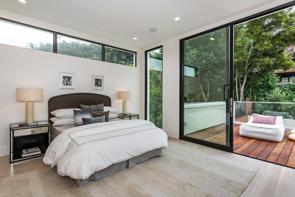 Inspiration for a large modern master bedroom in San Francisco with white walls, light hardwood flooring and beige floors.