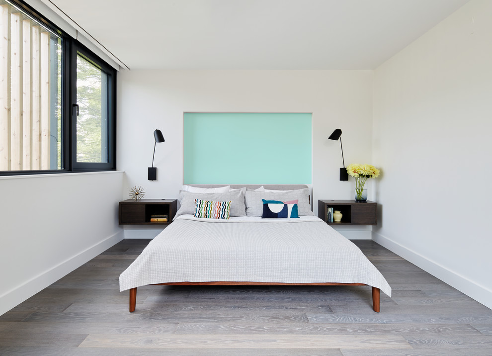 Immagine di una camera degli ospiti design con pareti bianche, parquet scuro e pavimento marrone