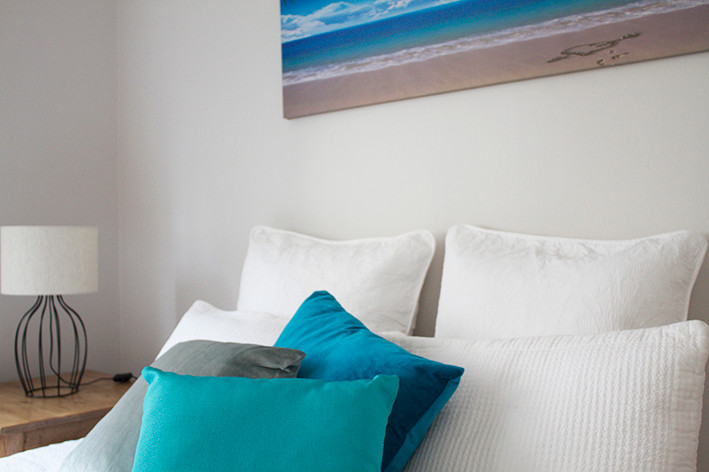 シドニーにある中くらいなビーチスタイルのおしゃれな主寝室 (グレーの壁、無垢フローリング、暖炉なし) のインテリア