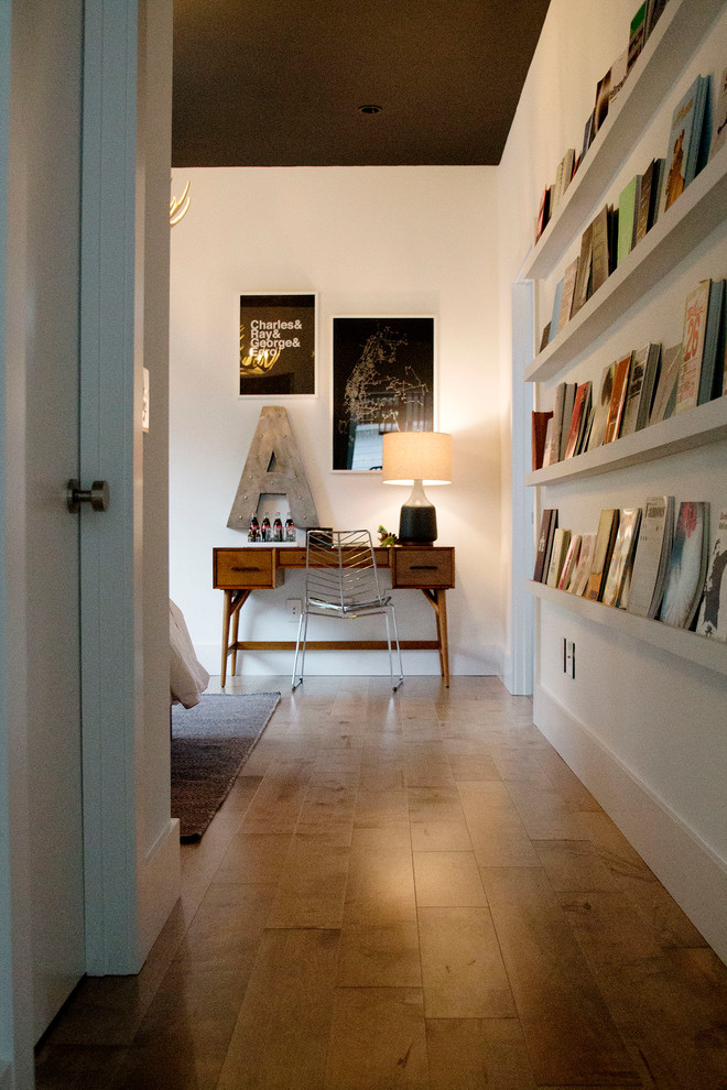 Cette image montre une chambre d'amis design de taille moyenne avec un mur blanc, un sol en bois brun et aucune cheminée.