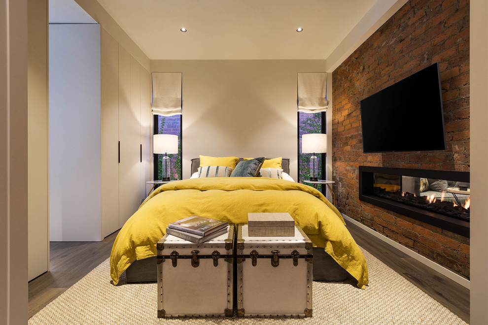 Пример оригинального дизайна: хозяйская спальня среднего размера в современном стиле с белыми стенами, паркетным полом среднего тона, коричневым полом, двусторонним камином, фасадом камина из металла и кирпичными стенами