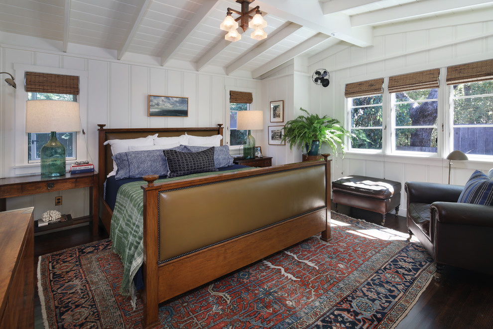 Diseño de dormitorio principal marinero con paredes blancas, suelo de madera oscura y suelo marrón