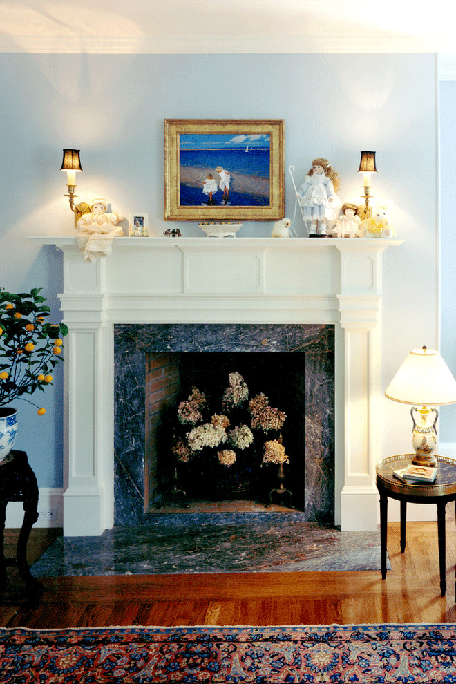 Пример оригинального дизайна: гостевая спальня среднего размера, (комната для гостей) в классическом стиле с синими стенами, паркетным полом среднего тона, стандартным камином и фасадом камина из камня