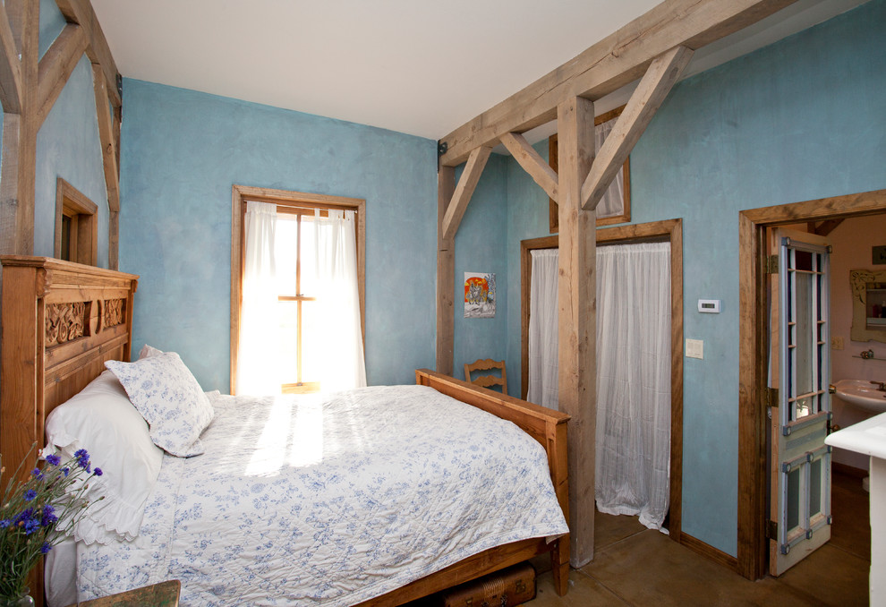 Diseño de dormitorio de estilo de casa de campo sin chimenea con paredes azules
